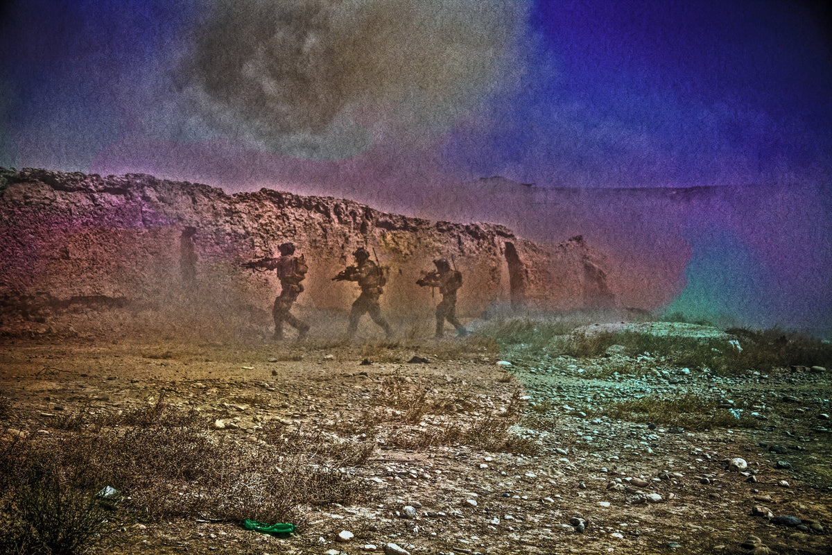 Team moving through a desert training course with smoke in the background