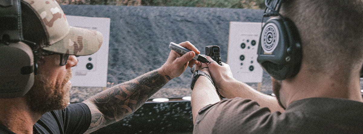 Instructor coaching a shooter on the pistol draw at the range